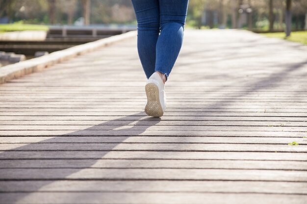 Menina andando no caminho no parque da cidade