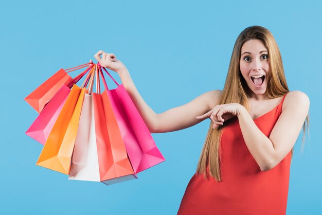 Menina apontando para sacolas de compras