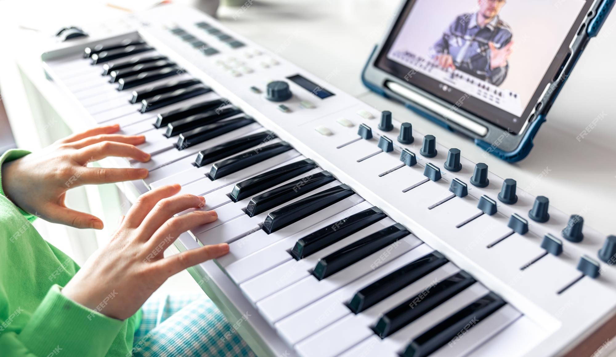 Menina aprende a tocar piano com música online para ensino à