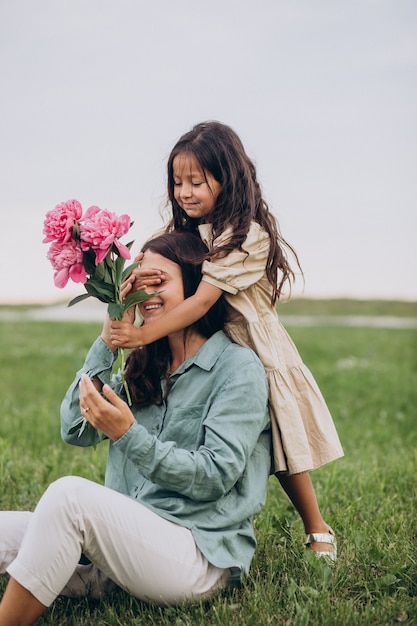 Menina apresentando flores para a mãe