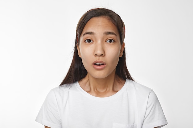Menina asiática expressiva posando em ambiente fechado