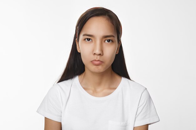 Menina asiática expressiva posando em ambiente fechado