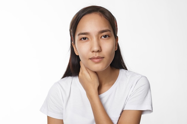 Menina asiática expressiva posando em ambiente fechado