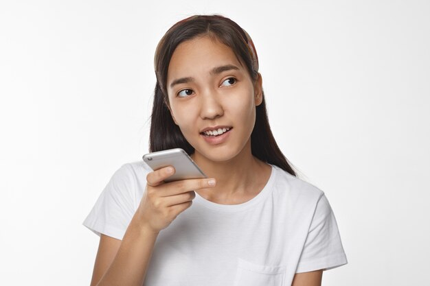 Menina asiática expressiva posando em ambiente fechado