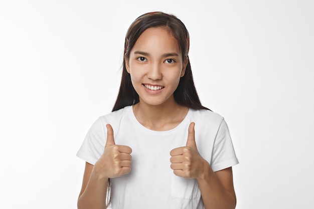 Menina asiática expressiva posando em ambiente fechado