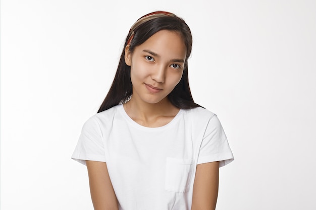 Menina asiática expressiva posando em ambiente fechado