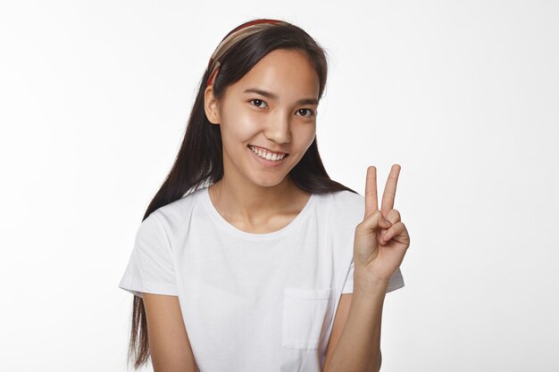 Menina asiática expressiva posando em ambiente fechado