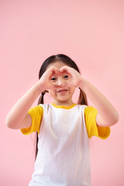Menina asiática fazendo sinal de coração com as mãos