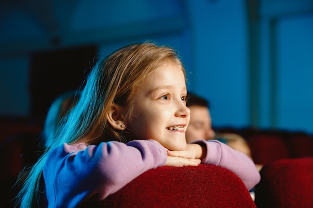 Menina assistindo a um filme no cinema