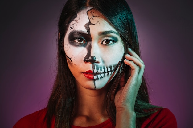 Menina assustadora com maquiagem e máscara de Halloween