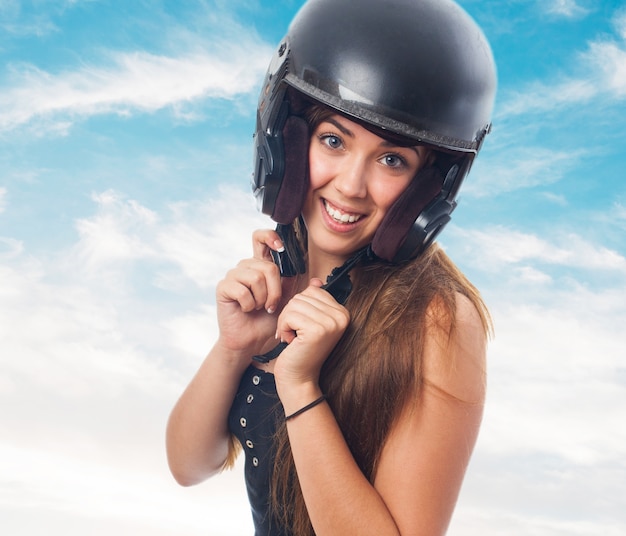 Menina atrativa que prende o capacete na cabeça.