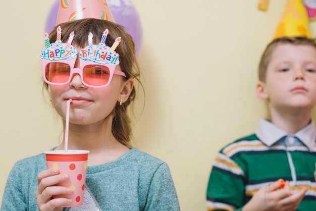 Menina bebendo bebida saborosa na festa