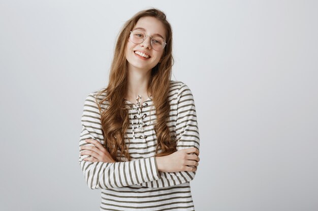 Menina bonita alegre da faculdade de óculos sorrindo