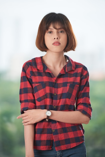 Foto grátis menina bonita asiática, olhando para a câmera, vestindo camisa xadrez