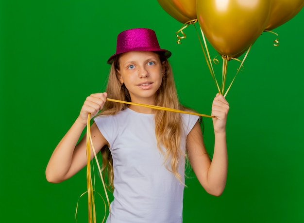 Menina bonita com chapéu de natal e um monte de balões