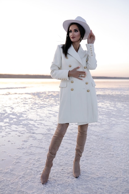 Foto grátis menina bonita com jaleco branco com sapatos de inverno menina européia com casaco sorrindo em um dia frio senhora morena alegre se divertindo durante a sessão de fotos moderna salt lake