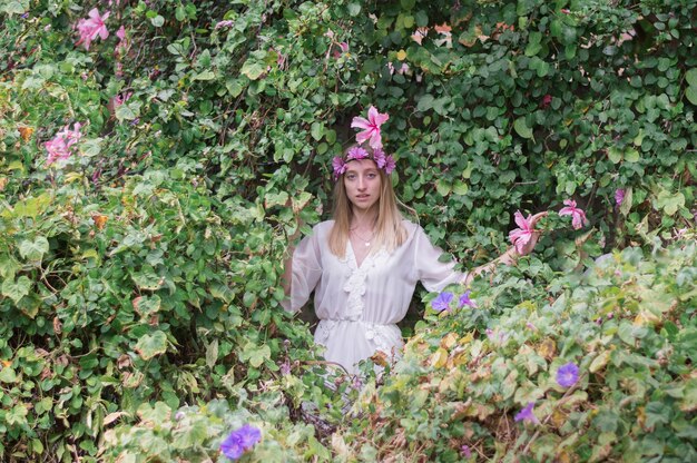 Menina bonita com levantamento coroa de flores