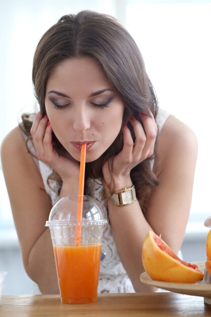 Menina bonita com suco de laranja