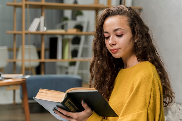 Foto grátis menina bonita de tiro médio, lendo um livro