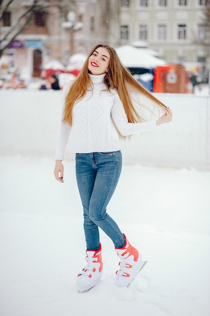 Menina bonita e linda com um suéter branco em uma cidade de inverno