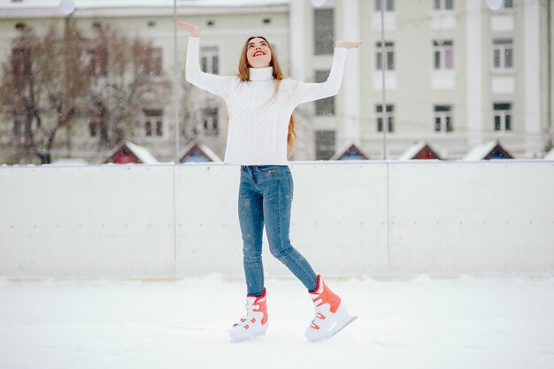 Menina bonita e linda com um suéter branco em uma cidade de inverno