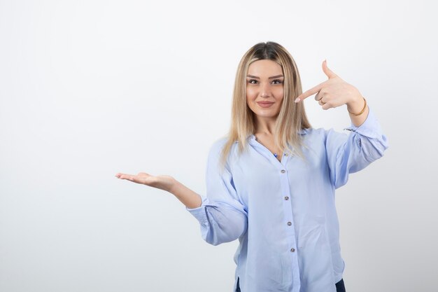 Menina bonita jovem em pé e posando em branco.