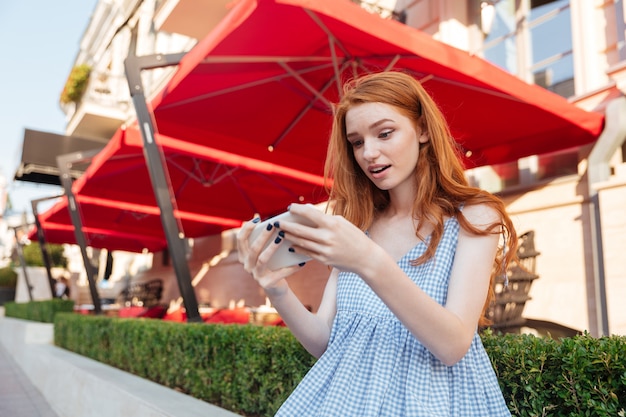 Menina bonita jovem jogando jogos no celular