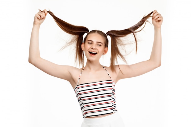 Foto grátis menina bonita jovem sorrindo, isolado na parede branca