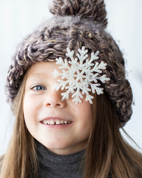 Menina bonita loira com floco de neve nos olhos