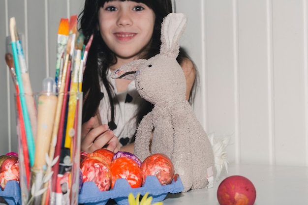 Foto grátis menina bonita perto de coelho e ovos coloridos