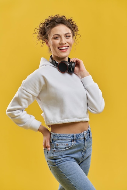 Foto grátis menina bonita posando com fones de ouvido no pescoço