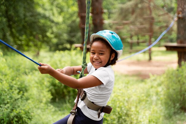 Menina bonita se divertindo em um parque de aventura