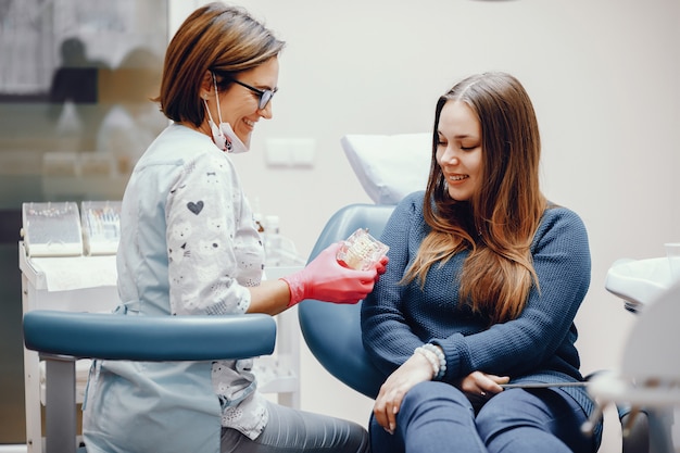 Menina bonita sentada no consultório do dentista