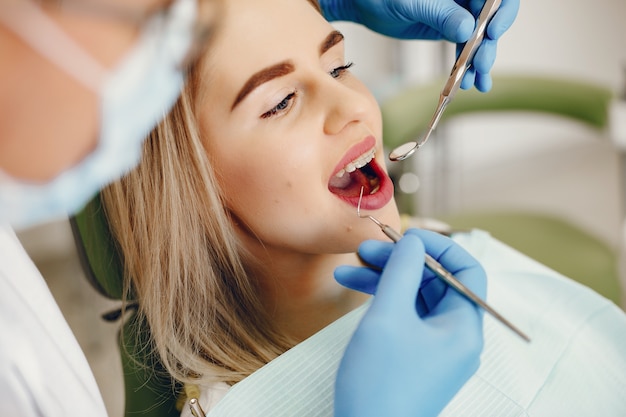 Menina bonita sentada no consultório do dentista