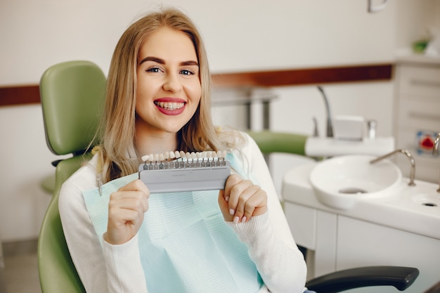 Menina bonita sentada no consultório do dentista