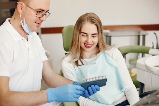 Menina bonita sentada no consultório do dentista