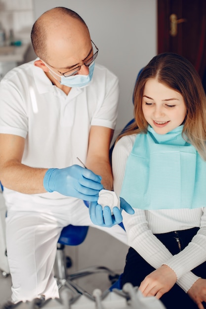 Menina bonita sentada no consultório do dentista