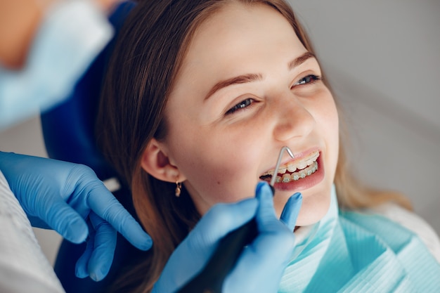 Menina bonita sentada no consultório do dentista