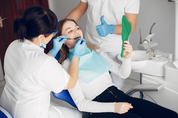 Menina bonita sentada no consultório do dentista