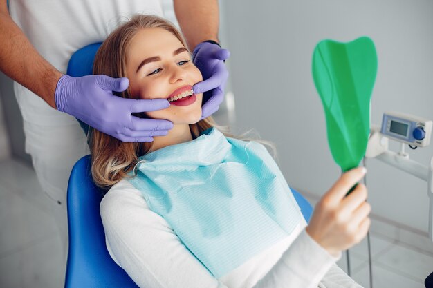 Menina bonita sentada no consultório do dentista