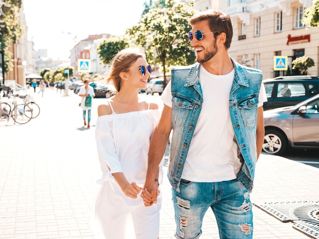 Menina bonita sorridente e seu namorado bonito andando na rua.