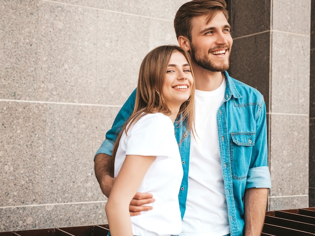 Menina bonita sorridente e seu namorado bonito em roupas de verão casual. Família feliz, tendo selfie auto-retrato de si na câmera do smartphone. Se divertindo no fundo da rua