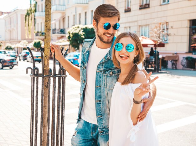 Menina bonita sorridente e seu namorado bonito posando na rua.