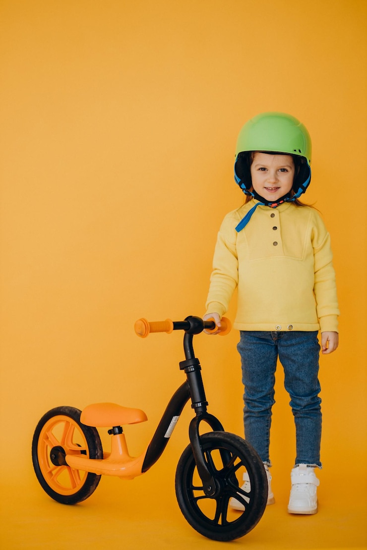 Foto grátis menina bonitinha aprendendo a andar de bicicleta