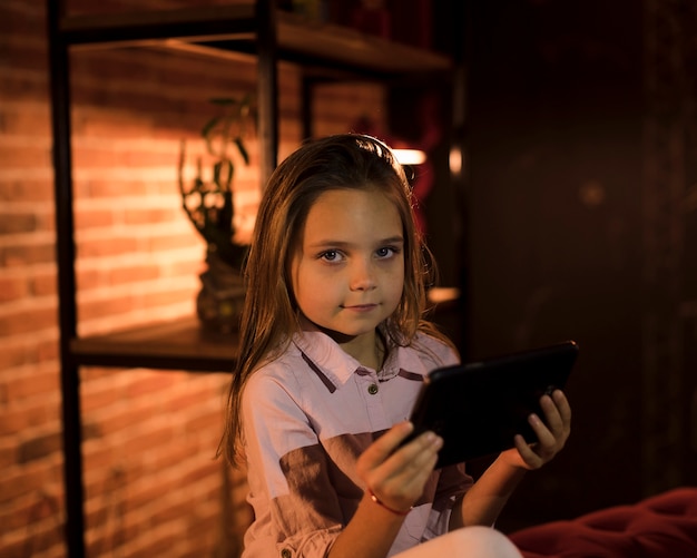 Foto grátis menina bonitinha brincando no seu tablet