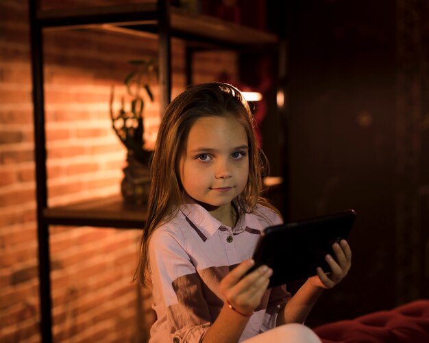 Menina bonitinha brincando no seu tablet