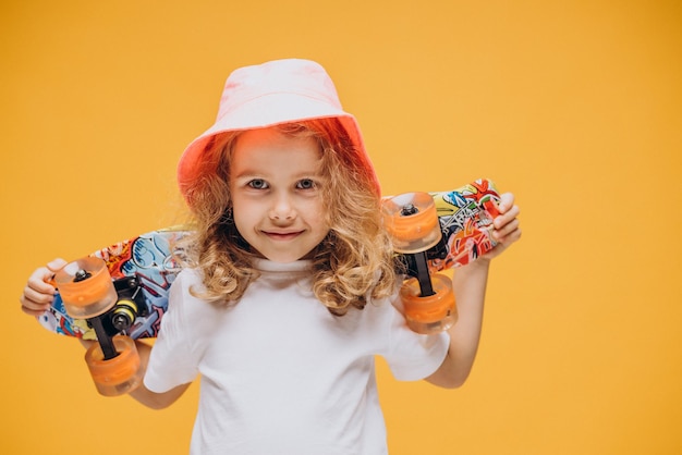 Menina bonitinha com prancha de skate isolada em estúdio