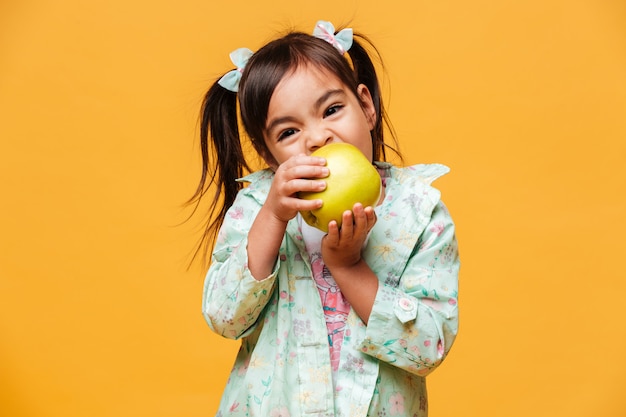 Foto grátis menina bonitinha comendo maçã.