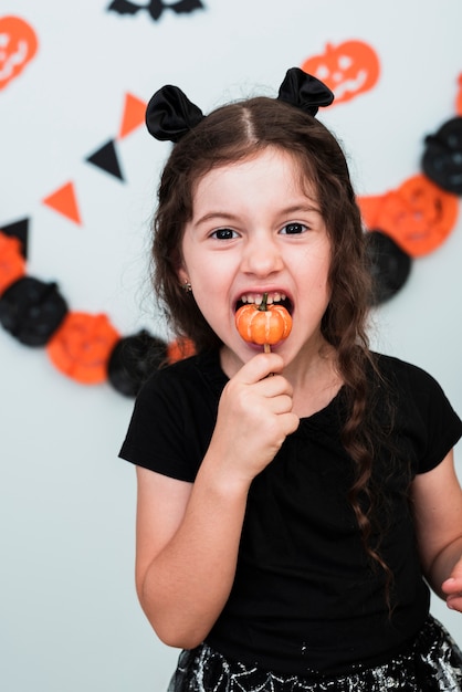 Foto grátis menina bonitinha comendo um doce pumpking