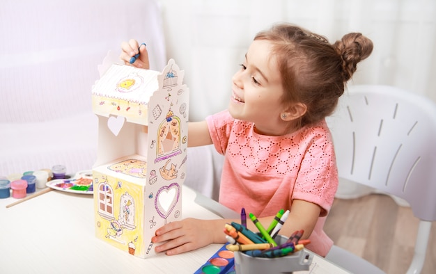 Menina bonitinha desenhando com lápis em casa